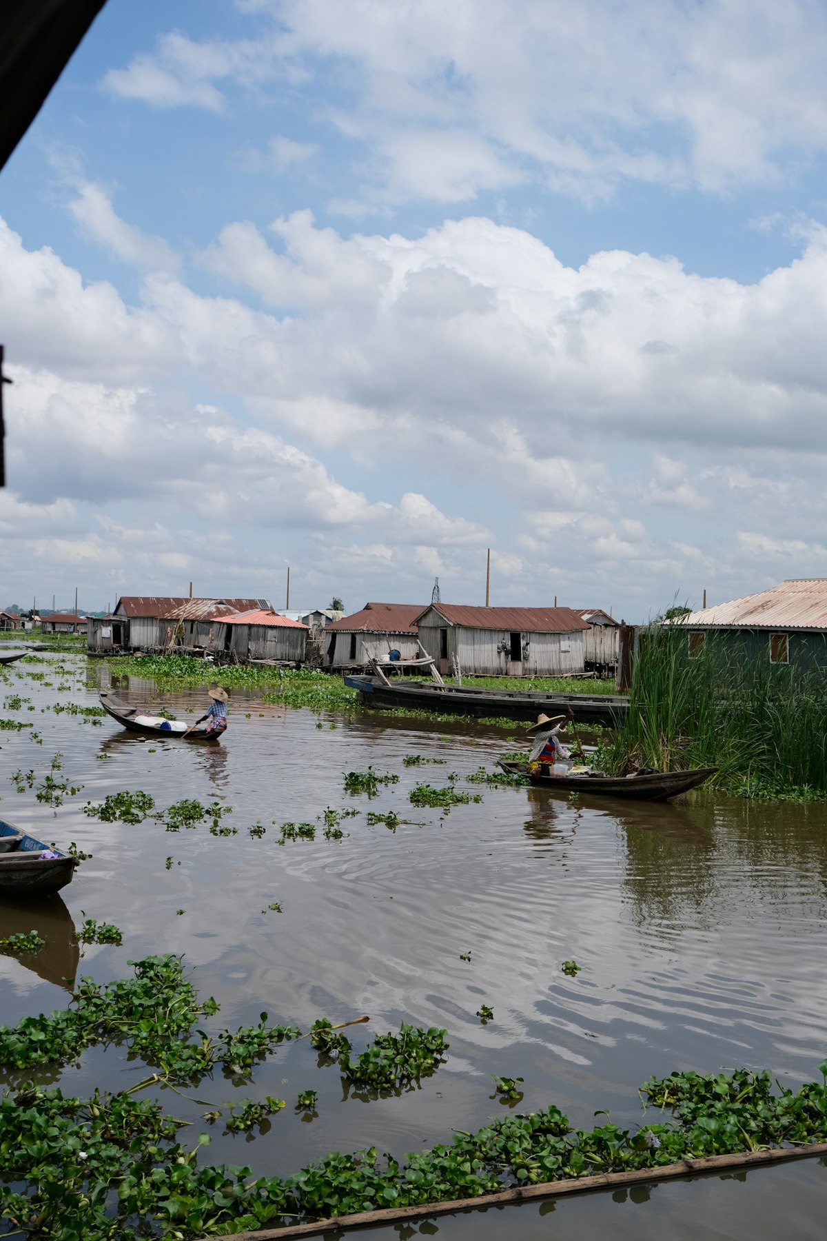 Wooden boats moving between stilt houses in Ganvié, Benin